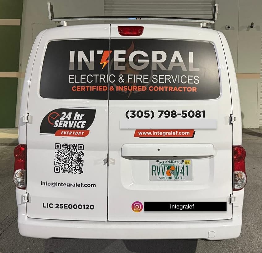 Rear of Integral Electric & Fire Services branded service van — 24-hour service, license #25E000120